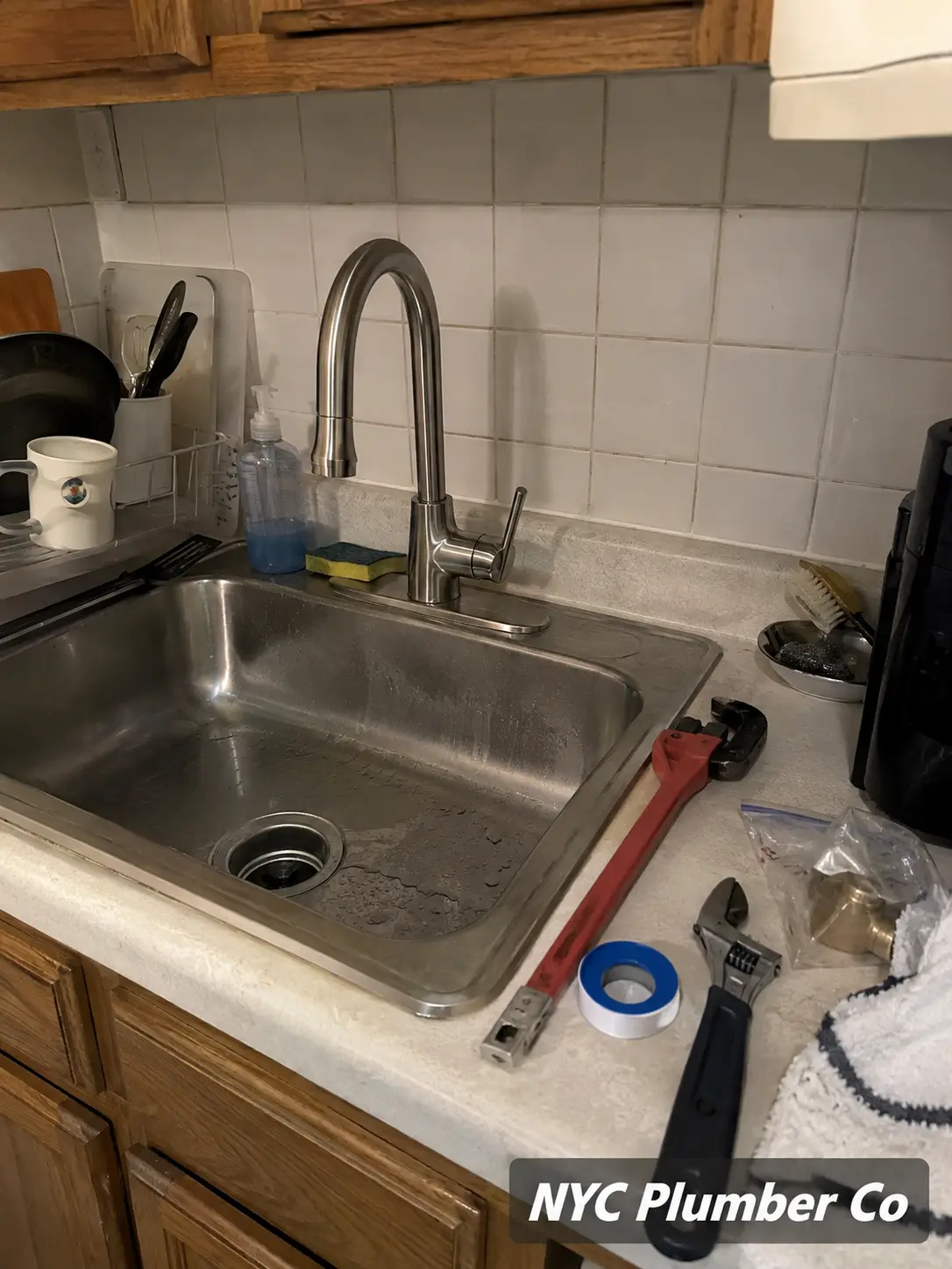 Kitchen faucet installation with tools on the counter